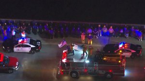 Law enforcement officials and firefighters salute slain Sgt. Steve Owen during a procession on Oct. 5, 2016. (Credit: KTLA)