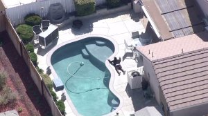 A man surrenders after a sheriff's sergeant was shot in Lancaster on Oct. 5, 2016. (Credit: KTLA)