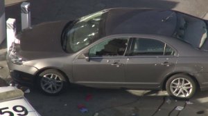 A vehicle involved in a police shooting in Torrance on Oct. 31, 2016 is seen at the scene with bullet holes in the windshield and a shattered driver's side window. (Credit: KTLA)