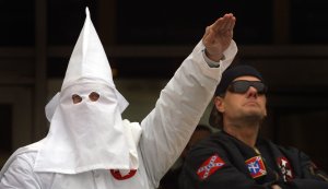 In this file photo, a hooded Klansman raises his left arm while another looks into the crowd during a Ku Klux Klan rally Dec. 16, 2000 in Illinois. (Credit: Tim Boyle/Newsmakers)
