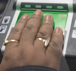 An international traveler scans in her hand on a U.S. Customs and Border Protection fingerprint scanner at Dulles International Airport for identity verification Feb. 20, 2013, outside of Washington, D.C. (Credit: PAUL J. RICHARDS/AFP/Getty Images)