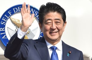 Japan's Prime Minister Shinzo Abe waves to well-wishers prior to boarding a government plane at Tokyo's Haneda on November 17, 2016. (CREDIT: KAZUHIRO NOGI/AFP/Getty Images)