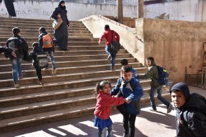 Syrian children cry and react after their school was reportedly hit by rebel rocket fire in the government-held side of west Aleppo, on Nov. 20, 2016. (Credit: George Ourfalian/AFP/Getty Images)