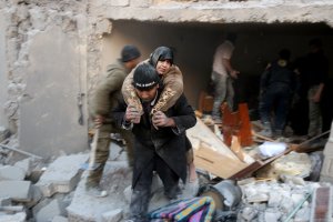 A Syrian rescuer carries a woman who was rescued from the rubble of a building following reported airstrikes on Aleppo's rebel-held district of al-Hamra on Nov. 20, 2016. (Credit: Thaer Mohammed/AFP/Getty Images)