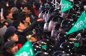 Riot police troops and protesters engage in a shoving match as the protesters attempt to march toward the presidential Blue House during a rally demanding the resignation of South Korea's President Park Geun-Hye in central Seoul on Nov. 26, 2016. (Credit: Jung Yeon-Je/AFP/Getty Images)