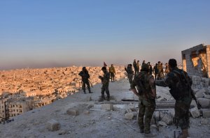 Syrian pro-government forces stand on top of a building overlooking Aleppo in the city's Bustan al-Basha neighbourhood on Nov. 28, 2016, during their assault to retake the entire northern city from rebel fighters. (Credit: George Ourfalian/AFP/Getty Images)