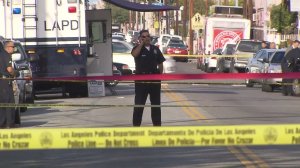 An LAPD officer is seen at the scene south of downtown where police fatally shot a man on Nov. 28, 2016. (Credit: KTLA)