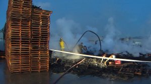Crews work to put out hot spots at a pallet yard fire in San Bernardino on Nov. 4, 2016. (Credit: KTLA)