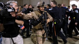 Police officers and U.S. Secret Service rush a man in handcuffs out of a campaign rally for Republican presidential nominee Donald Trump at the Reno-Sparks Convention Center Nov. 5, 2016 in Reno, Nevada. (Credit: Chip Somodevilla/Getty Images)