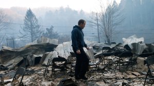 Trevor Cates, walks through the smoldering remains of the fellowship hall of his church, the Banner Missionary Baptist Church as he inspects damage after a wildfire November 29, 2016 in Gatlinburg, Tennessee. (Credit: Brian Blanco/Getty Images)