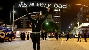 Protesters chant and wave signs as LAPD officers halt their march through downtown Los Angeles. (Credit: Luis Sinco / Los Angeles Times)