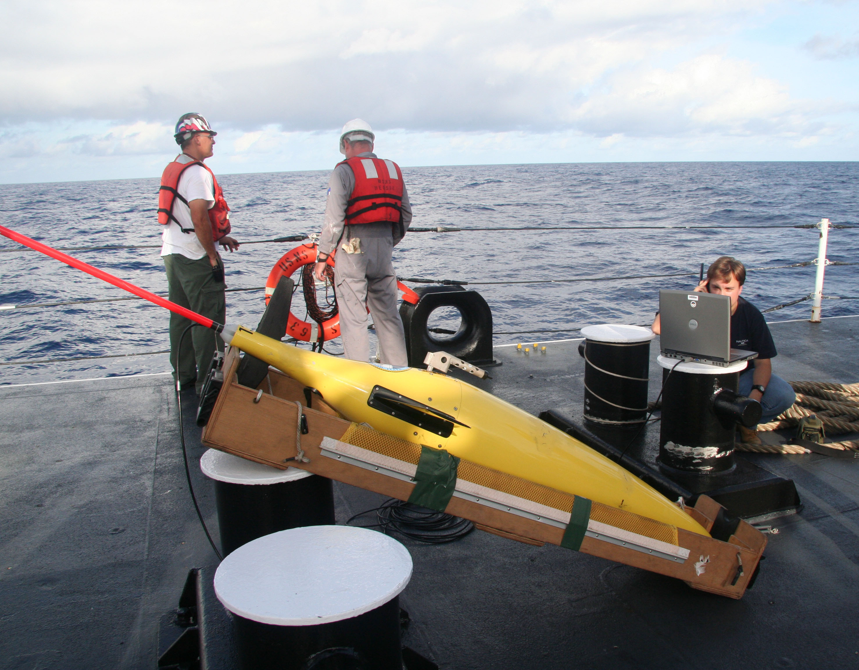 An oceanographer from the Naval Oceanographic Office, right, establishes a satellite connection before launching a seaglider unmanned underwater vessel from the Military Sealift Command oceanographic survey ship USNS Henson on March 24, 2010. (Credit: U.S. Navy / Petty Officer 2nd Class Lily Daniels)