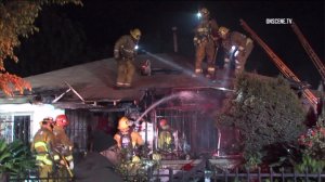 Fire crews are seen at a home that erupted in flames in South Los Angeles on Dec. 27, 2016. (Credit: OnScene.TV)