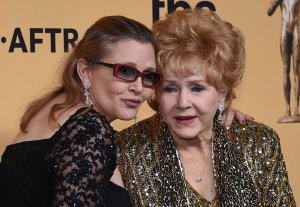 Debbie Reynolds, right, and her daughter, Carrie Fisher, pose in the press room during the 21st Annual Screen Actors Guild Awards at The Shrine Auditorium on January 25, 2015 in Los Angeles. (Credit: Ethan Miller/Getty Images)