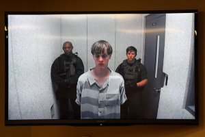 In this image from the video uplink from the detention center to the courtroom, Dylann Roof appears at Centralized Bond Hearing Court June 19, 2015, in North Charleston, South Carolina. (Credit: Grace Beahm-Pool/Getty Images)