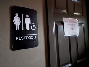 A unisex sign and the 'We Are Not This' slogan are outside a bathroom at Bull McCabes Irish Pub on May 10, 2016 in Durham, North Carolina. Debate over transgender bathroom access spreads nationwide as the U.S. Department of Justice countersues North Carolina Governor Pat McCrory from enforcing the provisions of House Bill 2 that dictate what bathrooms transgender individuals can use. (Credit: Sara D. Davis/Getty Images)