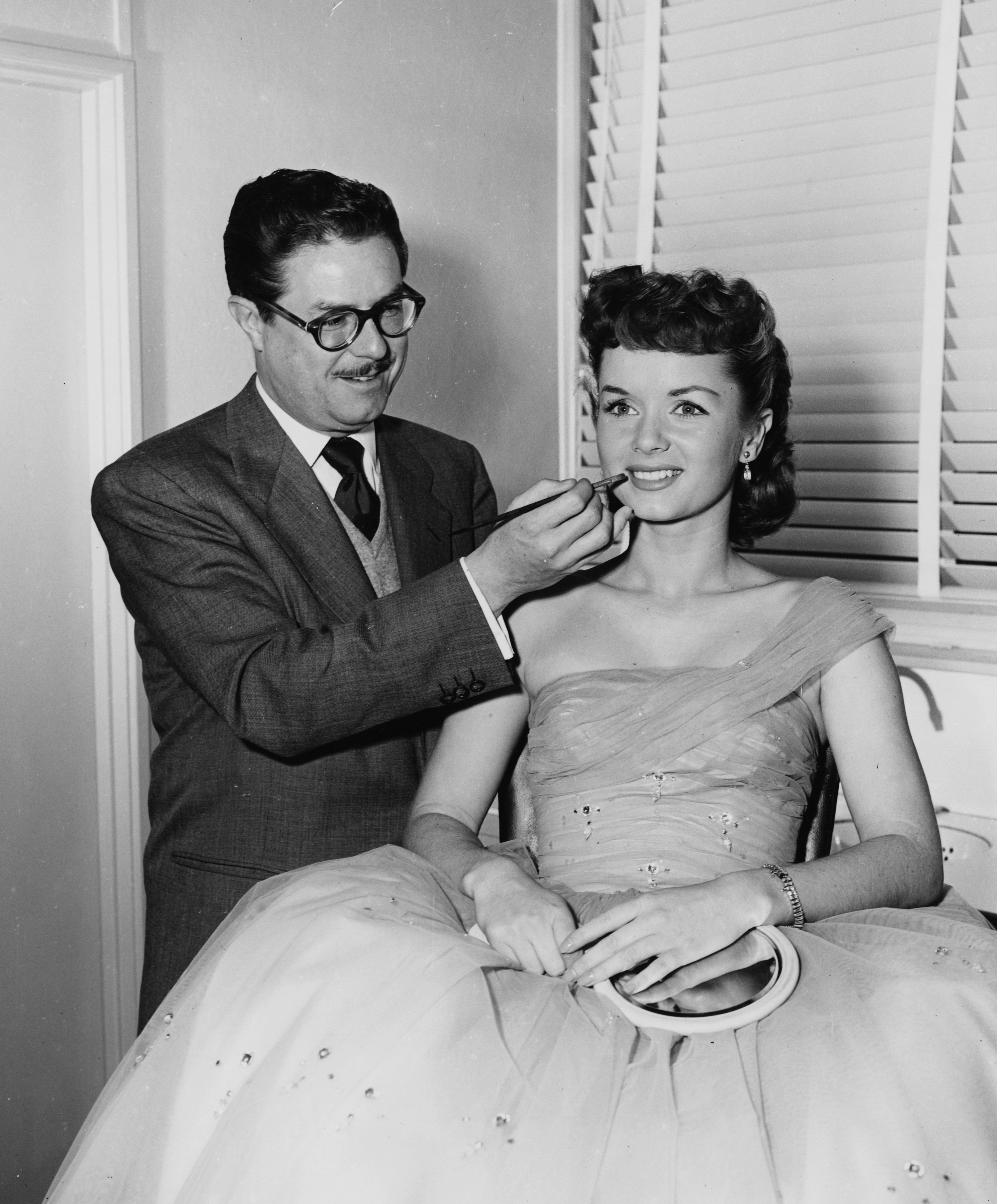 Makeup artist William J. Tuttle is seen applying lipstick on actress Debbie Reynolds, circa 1965. (Credit: Keystone/Hulton Archive/Getty Images)