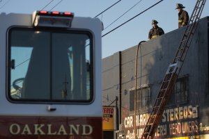 Firefighters investigate the scene of a overnight fire that claimed the lives of at least nine people at a warehouse in the Fruitvale neighborhood of Oakland on Dec. 3, 2016. (Credit: Elijah Nouvelage / Getty Images)