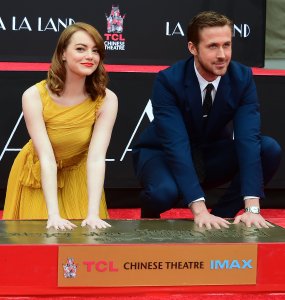 Actors Emma Stone and Ryan Gosling pose while placing their hands into the block of cement at their Hand and Foot prints ceremony in front of the TCL Chinese Theater in Hollywood on December 7, 2016 ahead of the release of the film LA LA Land set for December 9. (Credit: FREDERIC J. BROWN/AFP/Getty Images)