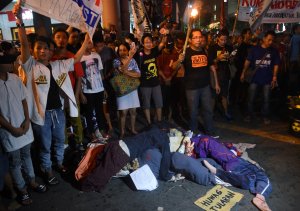 Activists carrying torchs and streamers stand next to manniquins depicting victims of extrajudicial killings in the government's war on drugs during a protest in observance of Human Rights Day, in Manila on December 10, 2016. President Duterte won presidential elections in May after pledging to kill tens of thousands of drug suspects, warning that otherwise the Philippines would turn into a narco-state. Since assuming office, he has called on police and even civilians to kill drug addicts. (Credit: TED ALJIBE/AFP/Getty Images)