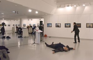 This picture taken on Dec. 19, 2016, shows Andrey Karlov, the Russian ambassador to Ankara, lying on the floor after being shot by a gunman, right, during an attack during a public event in Ankara. (Credit: STRINGER/AFP/Getty Images)