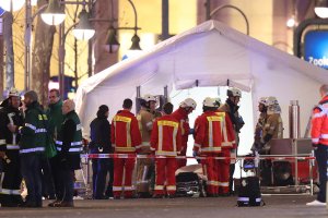 Rescue workers gather outside a tent in the area after a truck drove through a Christmas market on Dec. 19, 2016, in Berlin, Germany. (Credit: Sean Gallup/Getty Images)