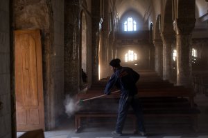 A man sweeps dust off seating in preparation for the Christmas Day mass at the Mar Hanna Church on Dec. 22, 2016 in Mosul, Iraq.(Credit: Chris McGrath / Getty Images)