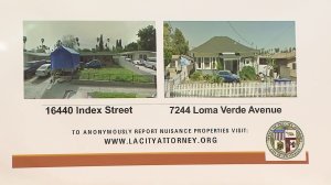 Photos of homes subject to city lawsuits related to a white supremacist gang are shown at a news conference on Dec. 13, 2016. (Credit: KTLA)