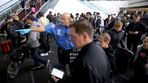 A TSA agent guides holiday travelers through a security checkpoint in Terminal 2 at LAX on Thursday, one of the busiest travel days of the year. (Credit: Luis Sinco / Los Angeles Times)