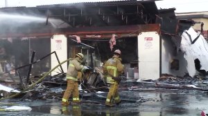 Fire crews continue to put out hot spots after a fire burned through a strip mall in Monterey Park on Dec. 15, 2016. (Credit: KTLA)