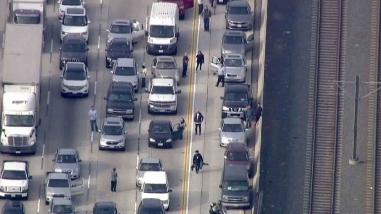 Some motorists got out of their car during a massive traffic jam on the 210 Freeway that was triggered when the roadway was closed for a police investigation on Dec. 7, 2016. (Credit: KTLA)