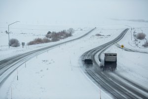 Trucks drive Highway 395 near Mammoth Lakes, California, January 9, 2017 as a series of strong storms moves through the state. (Credit: David McNew/AFP/Getty Images)