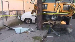 A crash left a school bus on top of a totaled parked vehicle in South L.A. on Jan. 27, 2017. (Credit: KTLA)