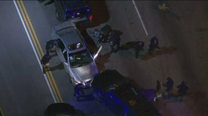 A man who led authorities on a slow-speed pursuit in the San Fernando Valley to the Sepulveda Pass is taken into custody on Jan. 10, 2017. (Credit: KTLA) 