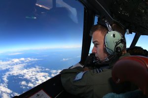 RAAF Flight Lieutenant Russell Adams looks out from the cockpit of an AP-3C Orion whilst on a search mission in the Southern Indian Ocean on March 26, 2014 in Perth, Australia. (Credit: Paul Kane/Getty Images)