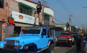 This picture taken on Jan. 3, 2017, shows pole dancers performing on top of jeeps during the funeral procession of former Chiayi City county council speaker Tung Hsiang in Chiayi City, southern Taiwan. (Credit: STR / AFP / Getty Images)