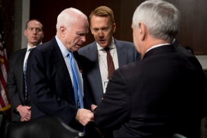 Chairman of the Senate Armed Services Committee U.S. Senator John McCain (second from left), R-Arizona, talks with a staffer prior to questioning Director of National Intelligence James Clapper during a hearing before the Senate Armed Services Committee on Capitol Hill in Washington, DC, Jan. 5, 2017. (Credit: Jim Watson / AFP / Getty Images)