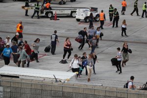 People seek cover on the tarmac of Fort Lauderdale-Hollywood International airport after a shooting took place near the baggage claim on January 6, 2017 in Fort Lauderdale, Florida. . (Credit: Joe Raedle/Getty Images)