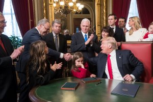 President Donald Trump shakes hands with Senate Minority Leader Chuck Schumer, D-N.Y, as he is joined by the Congressional leadership and his family while he formally signs his cabinet nominations into law, in the President's Room of the Senate, at the Capitol in Washington, Jan. 20, 2017. (Credit: J. Scott Applewhite - Pool/Getty Images)