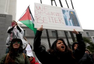 Protesters hold signs during a demonstration against U.S. President Donald Trump outside of Los Angeles City Hall on Jan. 20, 2017. (Credit: Justin Sullivan/Getty Images)