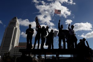 Marchers hold signs as they stand on a bus shelter during the Women's March on Jan. 21, 2017, in Los Angeles. (Credit: Justin Sullivan/Getty Images)