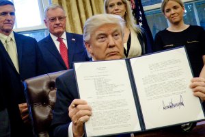 President Donald Trump holds up one of the executive actions that he signed in the Oval Office on Jan. 28, 2017 in Washington, DC. (Credit: Pete Marovich - Pool/Getty Images)