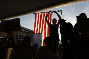 A demonstrator holds an American flag during a rally against muslim immigration ban at San Francisco International Airport on Jan. 28, 2017 in San Francisco, California. (Credit: Stephen Lam/Getty Images)