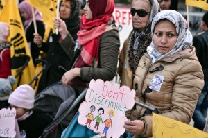 Afghan refugee women carry signs and wave flags during an demonstration in Athens on January 21, 2017, in solidarity with the Women's March on Washington, one day after the inauguration of Donald Trump as US President.  (Credit: Louisa Gouliamaki/AFP/Getty Images)