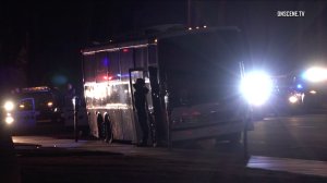 An individual exits a party bus with hands raised after the vehicle was pulled over in Huntington Beach on Jan. 7, 2017. (Credit: OnScene)