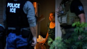 Immigration and Customs Enforcement officers looking for a fugitive migrant question his mother during a morning raid on his residence in Riverside. (Credit: Los Angeles Times)