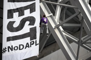 Protesters of the Dakota Access Pipeline unfurl a banner calling for the divestment of US Bank from the rafters during the second quarter of the Minnesota Vikings and Chicago Bears game on January 1, 2017. (Credit: Hannah Foslien/Getty Images)