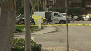 Police found two people shot to death inside a car that had crashed into a front yard in Pomona on Jan. 13, 2017. (Credit: KTLA)