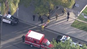 A person is taken to a waiting ambulance by emergency personnel following a shooting in Crenshaw on Jan. 31, 2017. (Credit: KTLA)