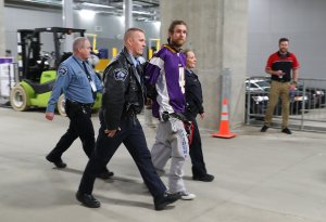 Police transport a protester after the Minnesota Vikings and Chicago Bears football game on January 1, 2017 at US Bank Stadium in Minneapolis, Minnesota. The protesters unfurled a banner in opposition to the Dakota Access Pipeline in the second quarter of the game. (Credit: Adam Bettcher/Getty Images)